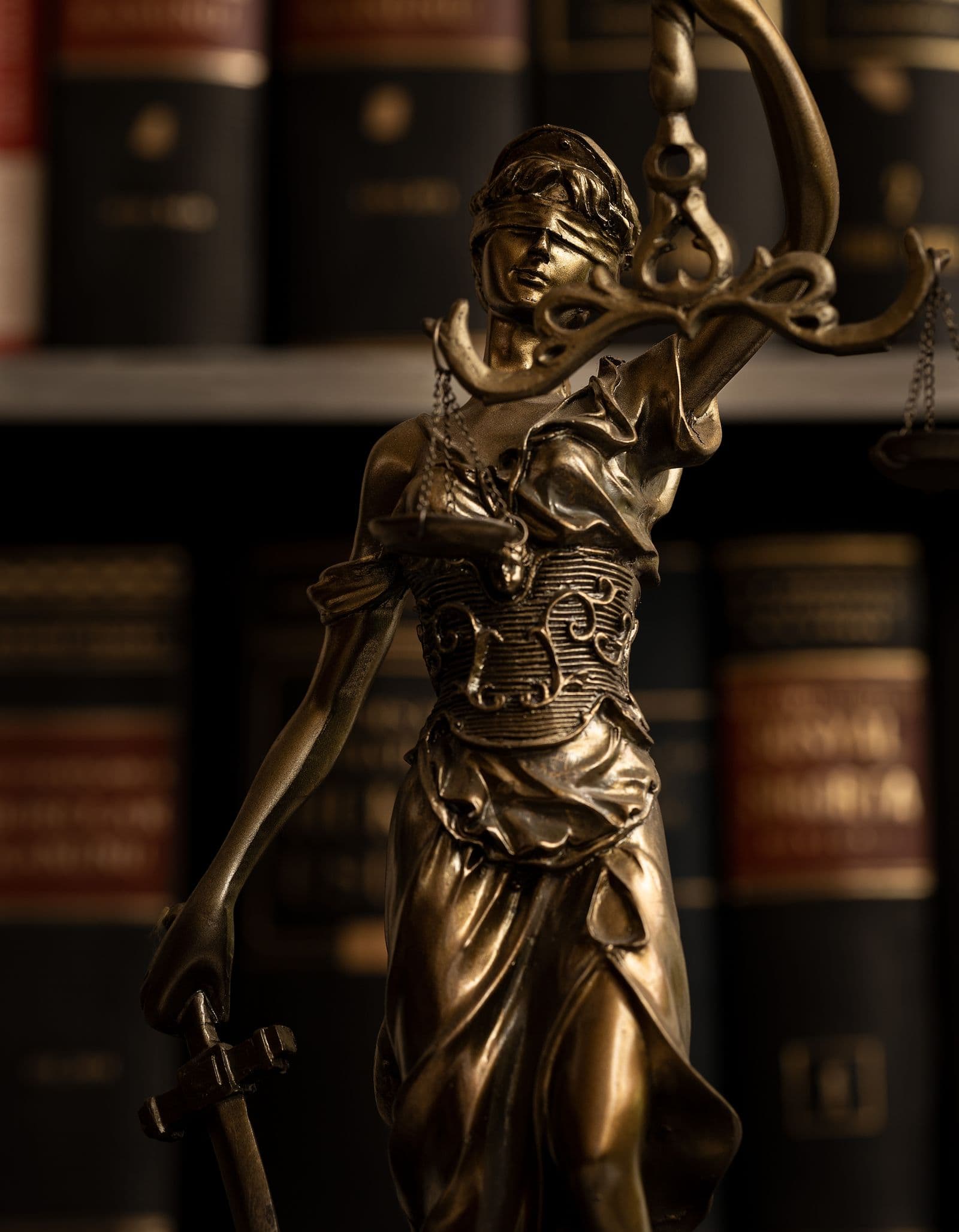 A golden figurine of Lady Justice holding scales