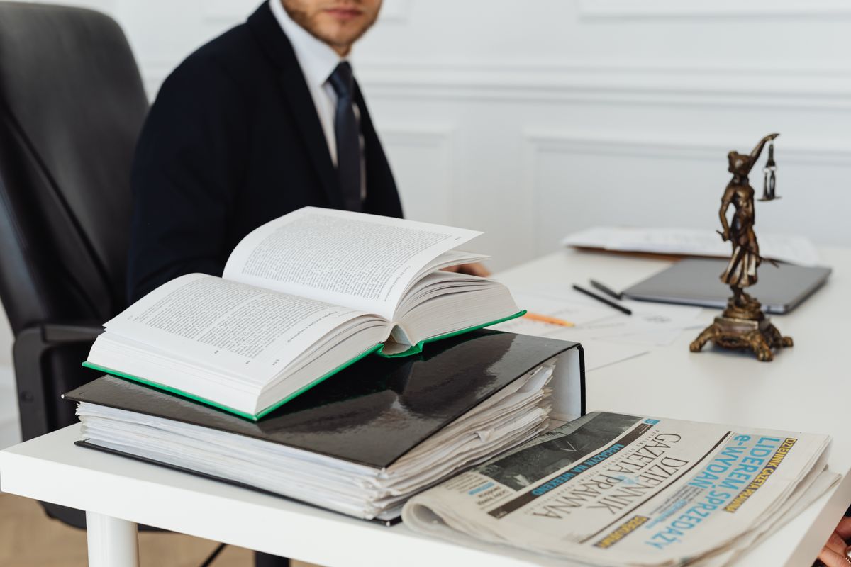 A book and a ring binder stacked on a desk